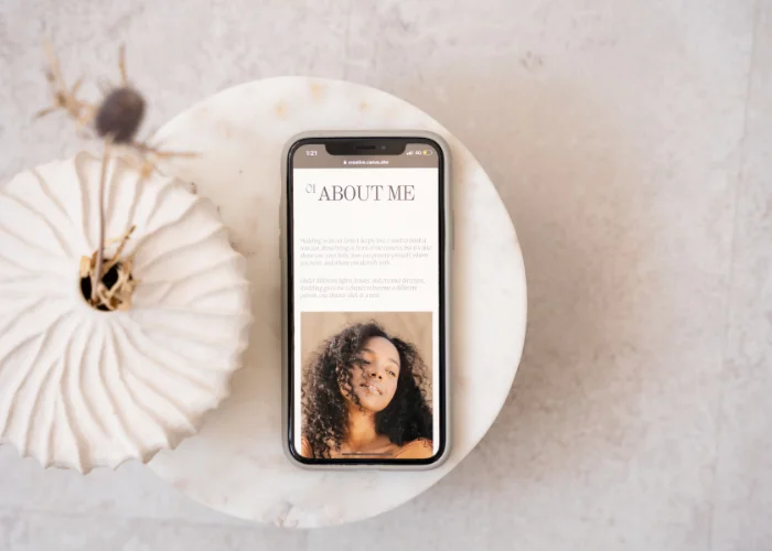 Smartphone affichant une page “About Me” élégante et minimaliste sur fond marbre - exemple d'optimisation SEO pour entrepreneurs